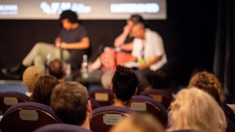 People seated in a cinema watching a Q&A event in front of the screen