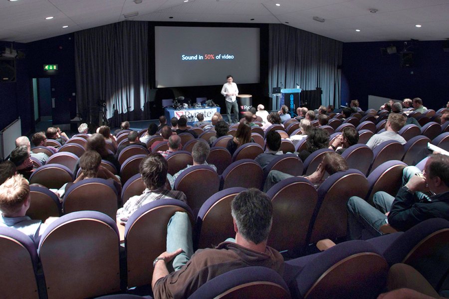 A view of Cinema 1 full of people seated at a conference event