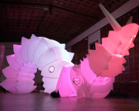 A large pink inflatable robotic snail inside a large hall.