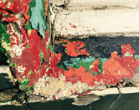 Layers of red, green and yellow peeling paint