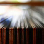 dark threads on a table, ready for weaving