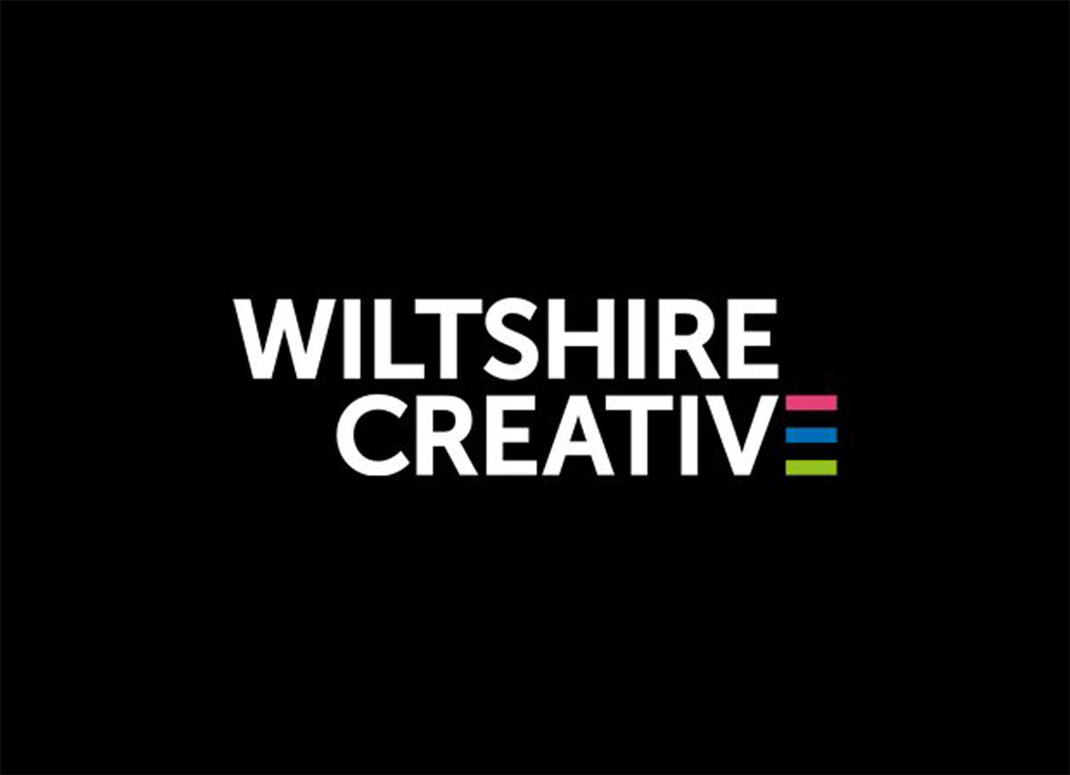 Graphic text image of Wiltshire Creative. White writing on black, and the 'E' in creative is comprised of colourful horizontal stripes