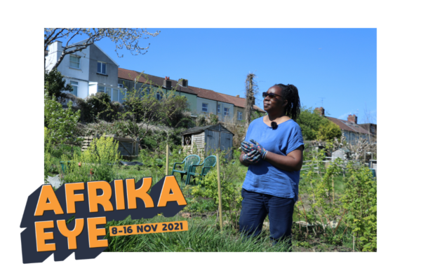 still from Africa eye short film woman stands in a Bristol allotment on a blue skied day.