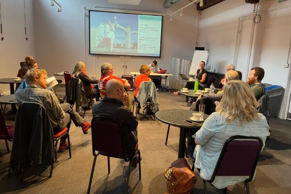 group of film hub members sat on chairs in a meeting room talking and sharing