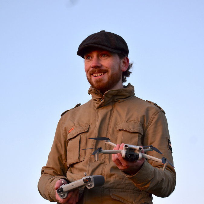 A man standing holding a drone.