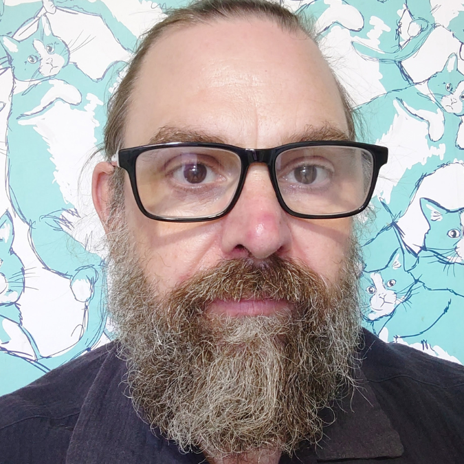 A head shot of a bearded man.