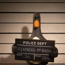 An stop-motion penguin holds a police sign, indicating he has been arrested.