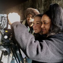 Image of three young filmmakers using camera equipment