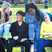 Group of young people on a bench laughing