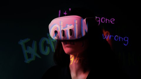 A person is wearing a Quest 3 headset and there are words projected across the wall