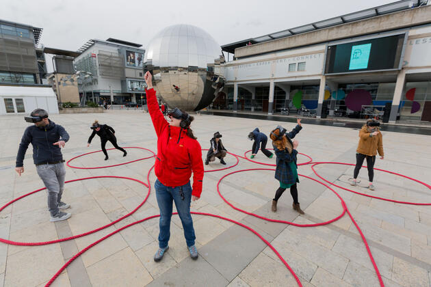 Photo of a group of people with VR masks on in Millennium Square, Bristol
